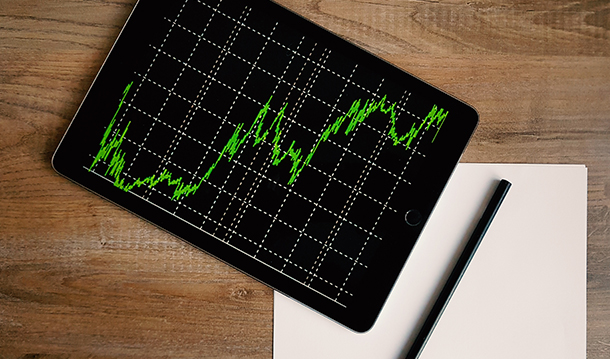 A tablet device showing an exponential growth investment chart